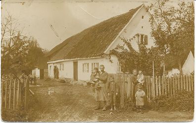 Anwesen Saur um 1914 Das Hausdach ist noch mit Stroh gedeckt. Auf dem Bild Joseph und Anna Saur mit den Kindern (v. li.) Josef, Heinrich (gefallen 1941), Anton (auf dem Arm der Mutter) und Martin (gefallen 1944)