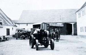 Auf dem Bayertomhof um 1934: Ein Dieselmotor ersetzt den Dampfkesselantrieb der Dreschmaschine. Bei diesem eisenbereiften Lanz handelt es sich um den ersten Traktor des Spar- und Darlehenskassenvereins.